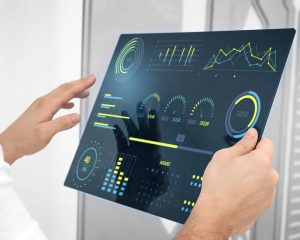A person shows a tablet with a dashboard representing data transformation.