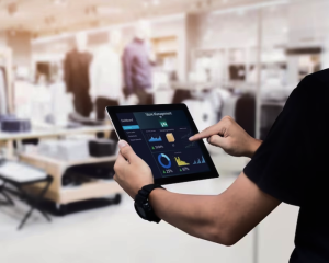 Man with tablet showing data analytics solutions for retail challenges.